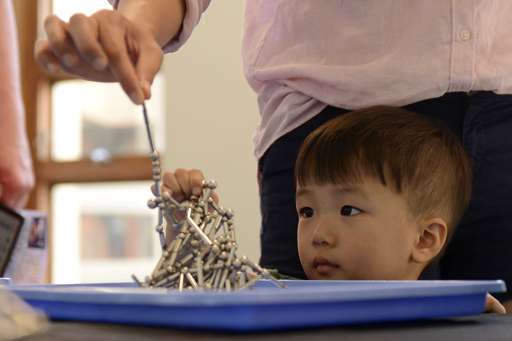Derik Jun, 2, plays with magnets during a chemistry show